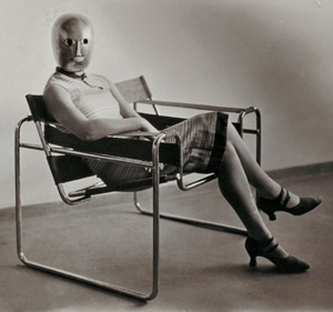 Erich Consemüller, Untitled (Woman in B3 club chair by Marcel Breuer wearing a mask by Oskar Schlemmer and a dress in fabric designed by Lis Beyer), ca. 1926.