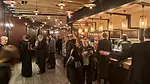 theater-goers gather around a lively bar