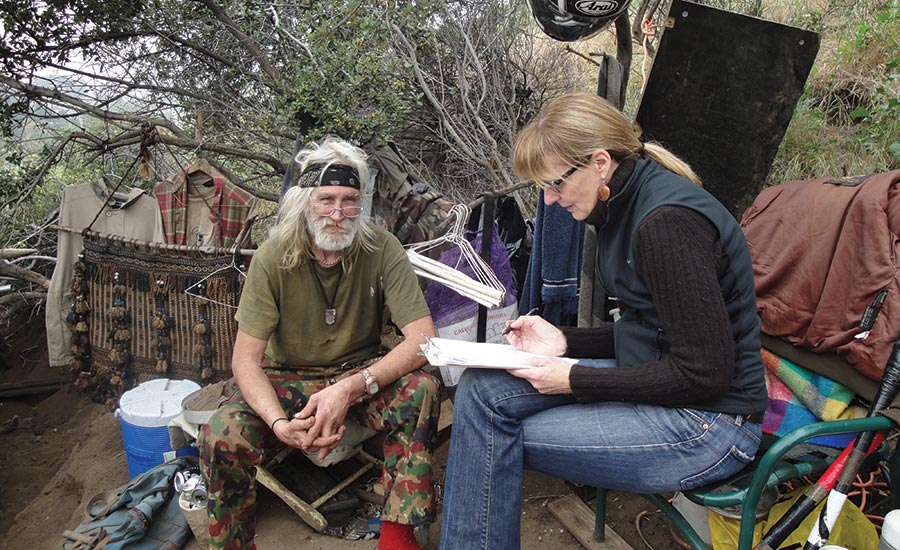 Outreach worker Kerry Morrison surveys a homeless man in Hollywood, California, for a Community Solutions initiative.