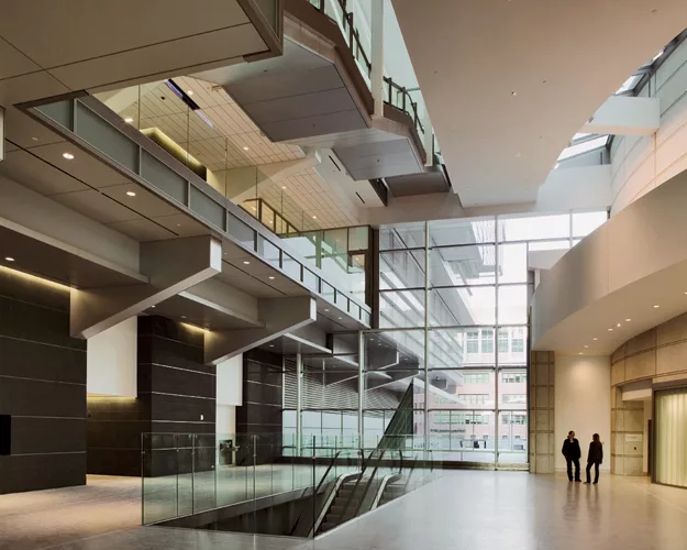 Displacement ventilation inside and a glazed curtain wall paired with interior light shelves are two of this building's sustainable strategies. 