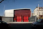 Ennead used immediately identifiable firehouse doors set into alternating glass and metal panels and wrapped in a form inspired by a firefighter's helmet for this Bronx station housing a specialized r