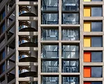 The renovated housing block includes a new, mirror-polished, steel-clad helical egress stair.