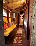 The hallway leading to the bedroom wing branches to the left as you enter the house. Wright used rough-sawn pine, stained the color of cedar for the interiors. The owners recently had interior designe