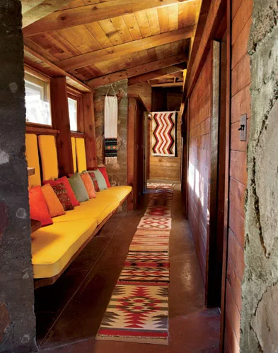 The hallway leading to the bedroom wing branches to the left as you enter the house. Wright used rough-sawn pine, stained the color of cedar for the interiors. The owners recently had interior designe