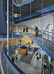 A helical stair connects upper and lower lobby levels.