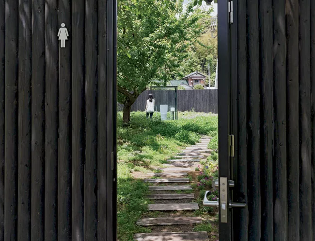 The architect's transparent stall (for women primarily) is surrounded by a 7-foot-high oval of wood fencing. The fence allows the stall's users to experience the scenic view while main