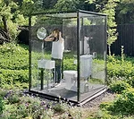 The architect's transparent stall (for women primarily) is surrounded by a 7-foot-high oval of wood fencing. The fence allows the stall's users to experience the scenic view while main