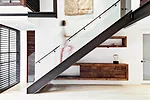 The repositioned stair comprises a steel stringer, enriched with reclaimed-wood treads and a transparent glass balustrade. Operable wood shutters, backed by glass panels that operate as dividers, 