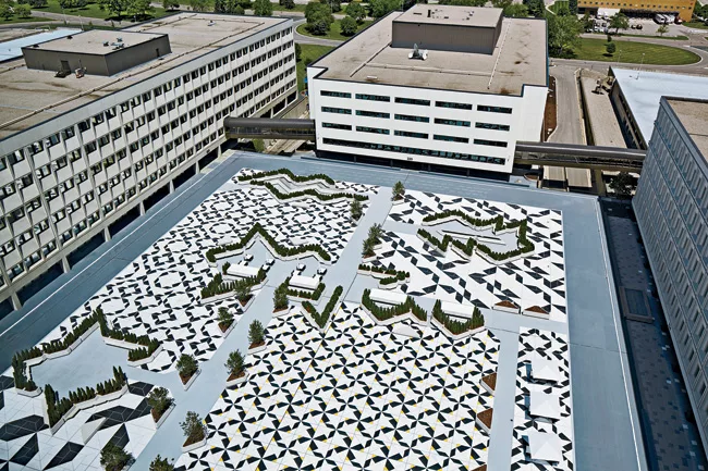 Abe and his team transformed a visitors’ parking lot (slide 3) at the center of the site into a plaza shared by all the surrounding buildings. Concrete benches and planters divide the large spac
