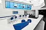 Five different &ldquo;hubs,&rdquo; each coded by a particular color, offer unprogrammed spaces for people to meet or relax. Overhead monitors and screens embedded in the work surfaces keep employees i