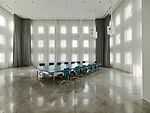 A boxy structure designed by Ebner and his firm stands in the plaza where the old visitors' entrance had been and serves as a dramatic space for important presentations and meetings. Curtains can be c