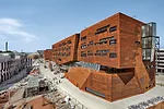 A Cor-Ten-clad building by BUSarchitektur houses lecture halls and a pair of atria that bring daylight inside. 