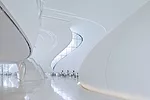 The unbridled swooping forms and blinding brightness of the glass-fiber-reinforced plastic exterior carry through to the building’s interiors, where floors merge into walls, stairs, and 