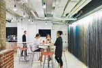 The café features exposed ceilings and an end wall painted by the staff to look like an abstract painting.