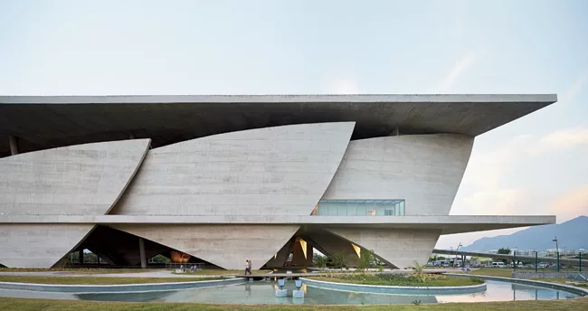 Sail-like sheets of structural concrete enclose theaters and support the elevated spaces.