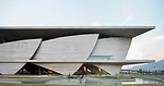 Sail-like sheets of structural concrete enclose theaters and support the elevated spaces.
