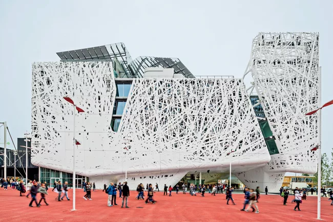 Designed by Studio Nemesi of Rome, the 150,000-square-foot building is wrapped in white concrete panels molded to look as if they were spun from threads. The concrete, made by Italcementi, is said to