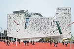 Designed by Studio Nemesi of Rome, the 150,000-square-foot building is wrapped in white concrete panels molded to look as if they were spun from threads. The concrete, made by Italcementi, is said to 