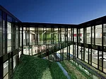 The design team transformed the precast-concrete former data center with a glazed courtyard; a shaded patio for outdoor lunches; and bleachers edged by stairs that provide a friendly spot for company 