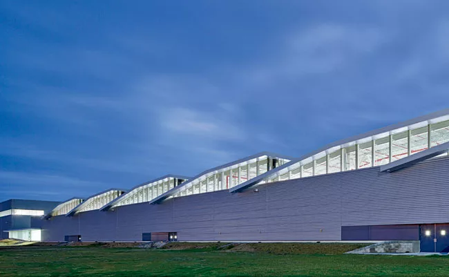 Balanced with an energy-efficient lighting system, a series of shed roofs and skylights were installed to infuse the factory with ample daylight&mdash;said to boost employee productivity&mdash;and als