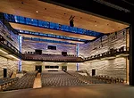 The performance hall has a proscenium stage and a two-level audience chamber. Board-formed concrete walls help amplify performances.