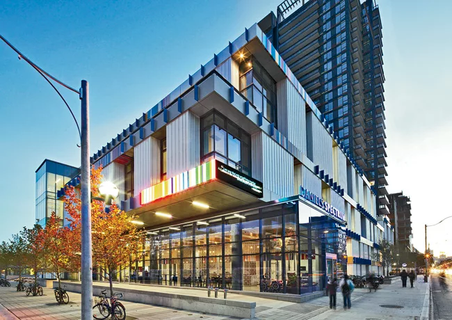 The three-story building anchors a key intersection of the revitalized 69-acre former low-rise community, which is being transformed by Toronto Community Housing Corporation and developer Daniels Corp