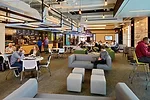 The fixtures are connected to a structural armature that can support hanging video screens or other elements. A caf' and lounge are open to all.