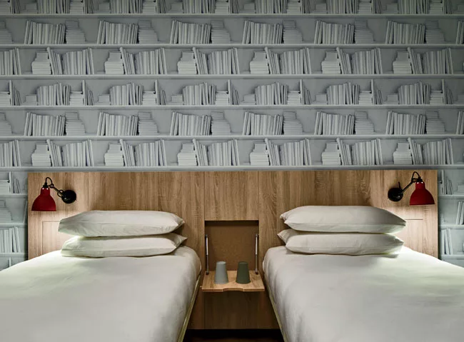 Private twin suites feature a trompe l'oeil wallcovering of books by Minehart, a nod to the bookstalls lining the Seine.
