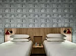 Private twin suites feature a trompe l'oeil wallcovering of books by Minehart, a nod to the bookstalls lining the Seine.