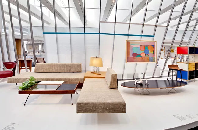 The sofas with an integral corner table were designed by architects A. Quincy Jones and Frederick Emmons in the 1960s. The rectangular cocktail table (circa 1950) is by Milo Baughman, while the E