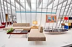 The sofas with an integral corner table were designed by architects A. Quincy Jones and Frederick Emmons in the 1960s. The rectangular cocktail table (circa 1950) is by Milo Baughman, while the E
