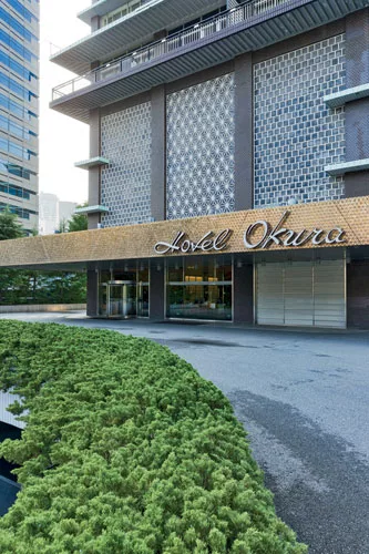 Located in the Akasaka area, near the U.S. embassy, the hotel opened in 1962 and was designed by Yoshiro Taniguchi and Hideo Kosaka. Its use of decorative <em>namako</em> wall tiling on the exterior b