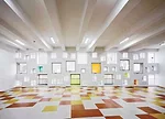 In the kindergarten, two parallel structures play in opposition to each other. A formidable concrete block encloses the circulation ramps for the school, while a punctured block with perforated alumin