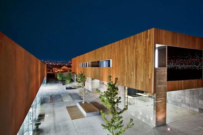 For a 9,622-square-foot cooking school in Tijuana, Gracia designed a pair of structures facing each other on a 10,760-square-foot site. A wide interior pedestrian street separates the two buildings an