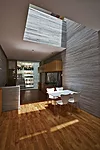 A pair of skylights and light wells give the reinforced-concrete structure the feeling of a traditional courtyard house, while tightly stacked courses of granite add texture to the interior spaces.