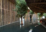 A pair of concentric crescents surrounded by a reflecting pool and nestled one within the other, this caf' in Binh Duong province places customers in a man-made landscape that helps connect interior a