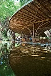 A pair of concentric crescents surrounded by a reflecting pool and nestled one within the other, this caf' in Binh Duong province places customers in a man-made landscape that helps connect interior a