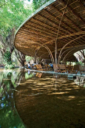 A pair of concentric crescents surrounded by a reflecting pool and nestled one within the other, this caf' in Binh Duong province places customers in a man-made landscape that helps connect interior a