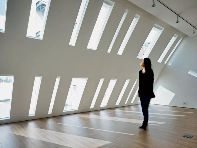 A commercial building in an upscale Tokyo neighborhood, the 3,875-square-foot Urbanprem Minamiaoyama was completed in 2008. Situated at the end of a quiet cul-de-sac, it greets the narrow street in fr