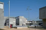 The 500-student school focuses inward around a small playing field, turning its back on the incomplete new development around it. Indoor and outdoor corridors circle the field and widen into courtyard
