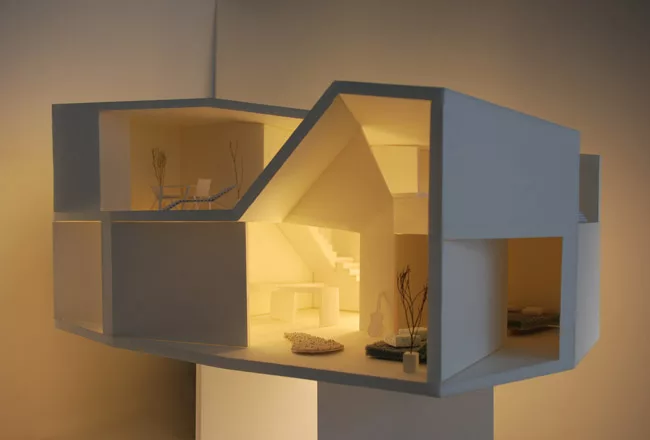 The client added a one-bedroom penthouse to the modest building where his mother and sister live. The architects oriented windows at oblique angles to the streets for views and protection from direct