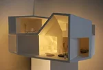 The client added a one-bedroom penthouse to the modest building where his mother and sister live. The architects oriented windows at oblique angles to the streets for views and protection from direct 