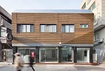 This residential project with street-front commercial spaces takes advantage of a grandfather clause that exempts existing buildings from having to provide parking. JOHO convinced the client to renova
