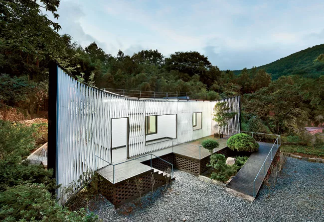 The owner of a Seoul design company owned an ugly brick house in the mountains in Namhae county, where he liked to escape. He decided to make it more welcoming, so he hired JOHO to remake the building