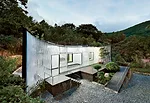 The owner of a Seoul design company owned an ugly brick house in the mountains in Namhae county, where he liked to escape. He decided to make it more welcoming, so he hired JOHO to remake the building