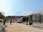 With this six-classroom addition to a primary school in Jiangxi Province, RUF produced a U-shaped structure with a courtyard open on one side. A continuous roof begins as a series of steps, providing 
