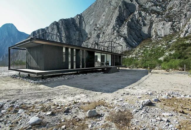 This weekend retreat for a young couple sits lightly atop columns on its awe-inspiring site surrounded by the Sierra Madre mountains in Nuevo Le&oacute;n state. The architects used scrap steel for muc