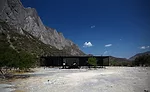 The diminutive house floats over the rugged terrain, enabling water runoff to pass below.