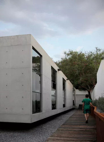 The house is set back from the street and neighboring properties, creating ample circulation space around the volume.