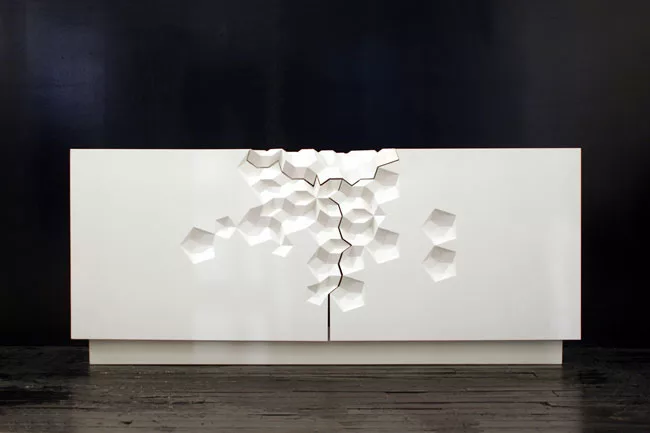 A lacquered wood cabinet designed by Aranda\Lasch is 30 by 72 by 18 inches in size, with a crystalline-CNC-milled motif. Craig Robins, CEO of Dacra, the Miami real-estate firm, purchased the limited-e